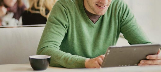 man in a green sweater, typing on his computer