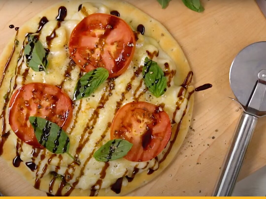 Stouffer's White Cheddar Macaroni and Cheese on a pizza with tomatoes