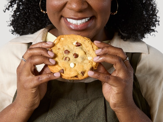 woman holding triple chip cookie in hands