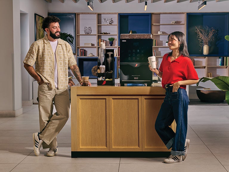 coffee machine with two people standing next to it