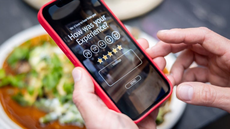 person using their cell phone to complete a survey with bowl of food underneath