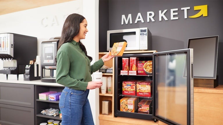 woman standing and reaching for a grab and go product