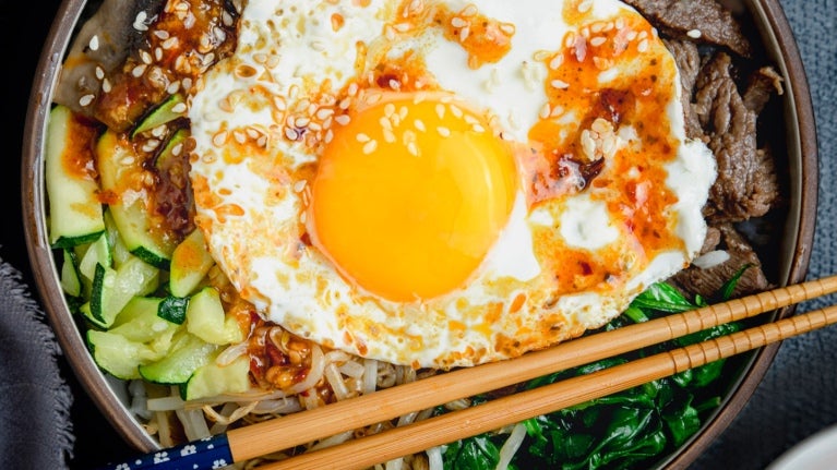 over easy egg on top of greens in bowl