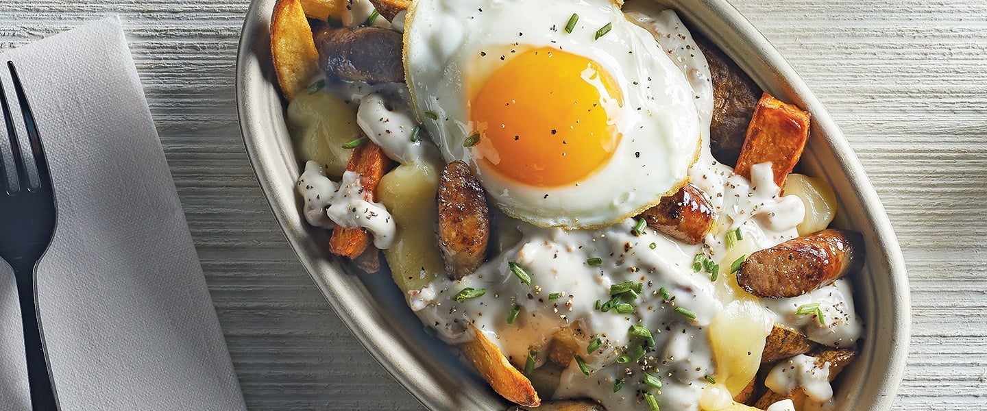 egg over hash entree in a to go bowl with a fork